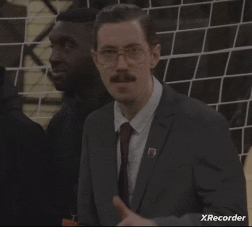 a man in a suit and tie giving a thumbs up with xrecorder in the corner