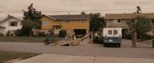 a man is riding a motorcycle on a ramp in front of a house .
