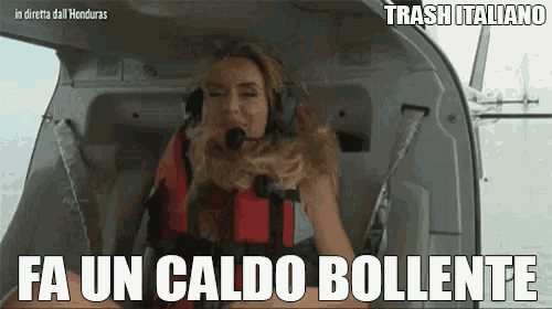 a woman sitting in a helicopter with the words fa un caldo bollente