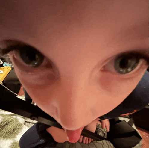 a close up of a person 's face with their tongue hanging out