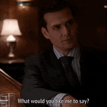 a man in a suit and tie is sitting at a bar and asking what would you like me to say