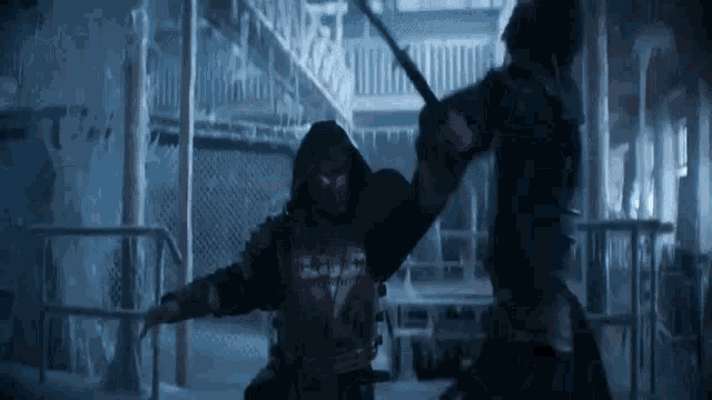 two men in armor are fighting with swords in a building .