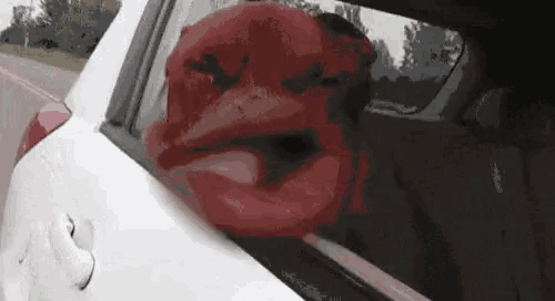 a close up of a car window with a red lip sticking out of it .