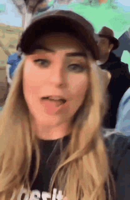 a woman wearing a hat and a t-shirt that says crossfit is making a funny face