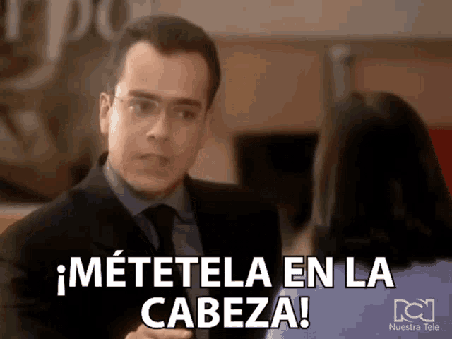 a man in a suit and tie talks to a woman in a nuestra tele advertisement
