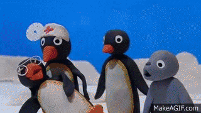 a group of stuffed penguins are standing next to each other on a blue background .