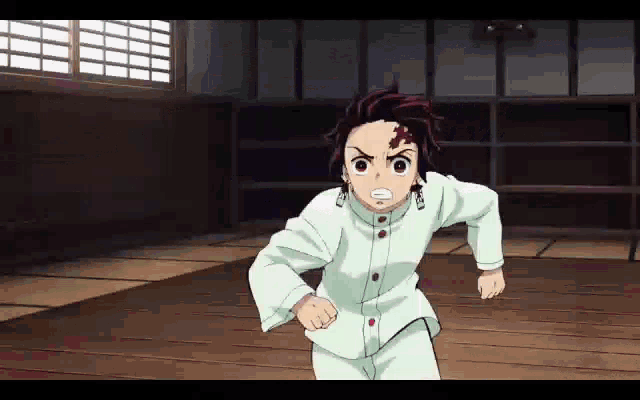 a young boy is running in a room with a wooden floor and a window .
