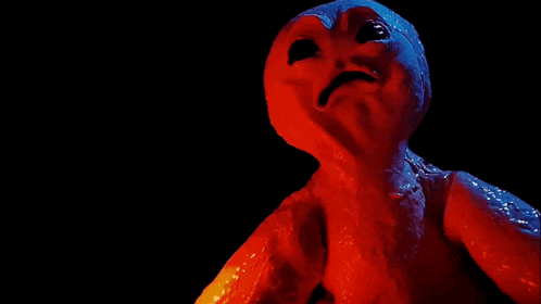 a red monster with a black background is making a funny face