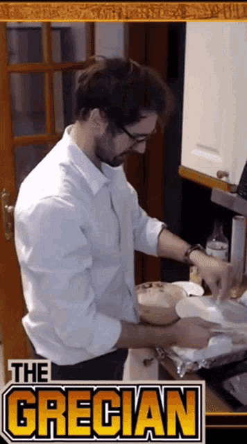 a man in a white shirt is preparing food in front of a sign for the grecian