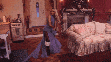a woman in a long purple dress is standing in a living room