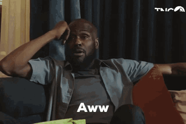 a man sitting on a couch says aww