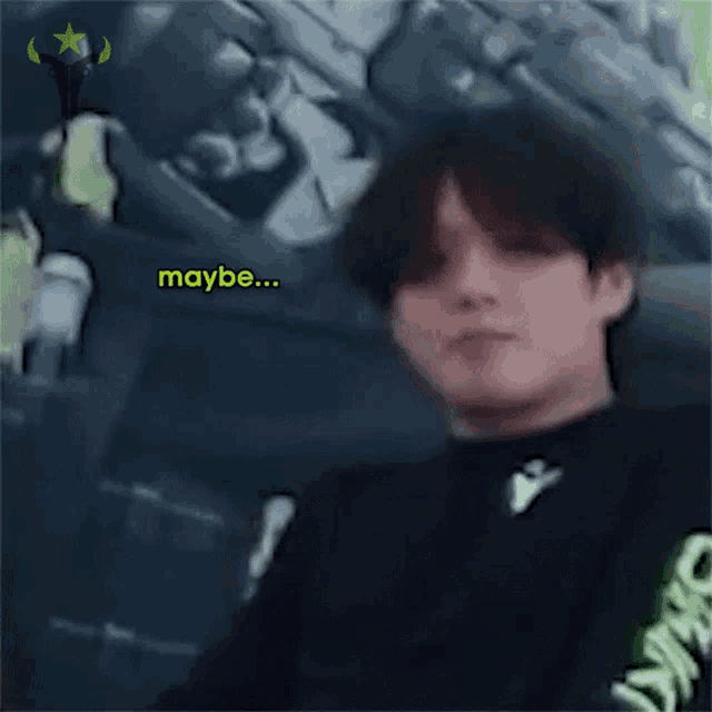 a man in a black shirt with the word maybe written on it