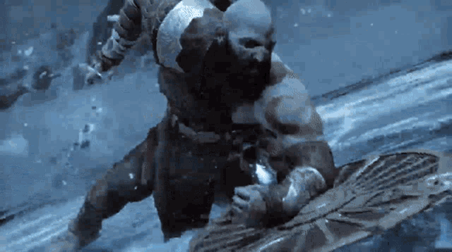 a man with a beard is standing in the water holding a shield and a sword .