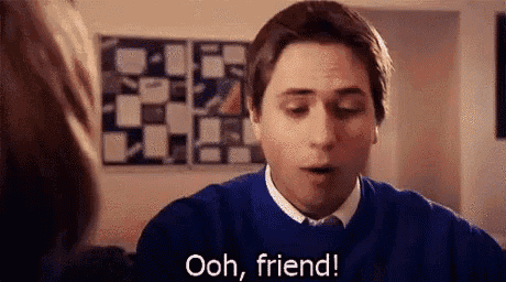 a man in a blue sweater and tie is talking to a woman and says `` ooh , friend ! ''
