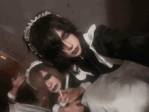 two girls dressed as maids are smoking cigarettes