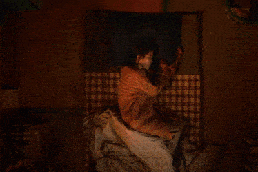 a woman is sleeping with her eyes closed and her hands on her face
