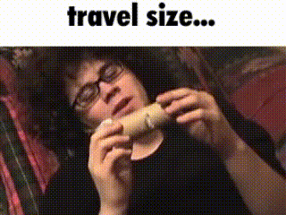 a man wearing glasses is holding a toilet paper roll with the words travel size written below him
