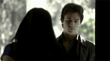 a man and a woman are standing next to each other looking at each other .