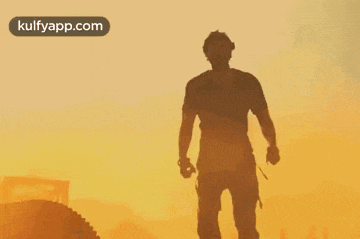a silhouette of a man standing in front of an orange sky