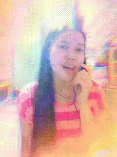 a woman in a pink and white striped shirt is smiling