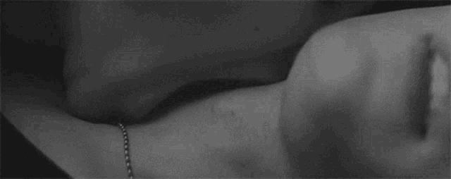 a black and white photo of a man and woman kissing .