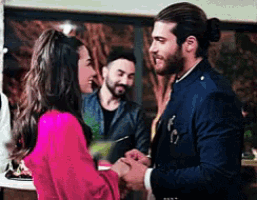 a man and a woman are standing next to each other and shaking hands .
