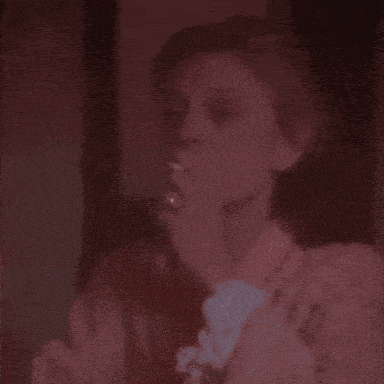 a woman is smoking a cigarette in a red room