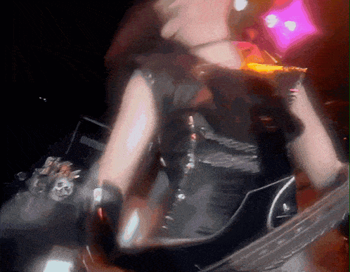 a blurry picture of a person playing a guitar in a dark room