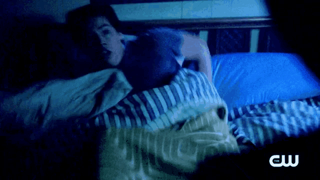 a person is laying in bed with a cw logo on the bottom
