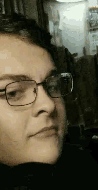 a close up of a woman wearing glasses and a black sweater