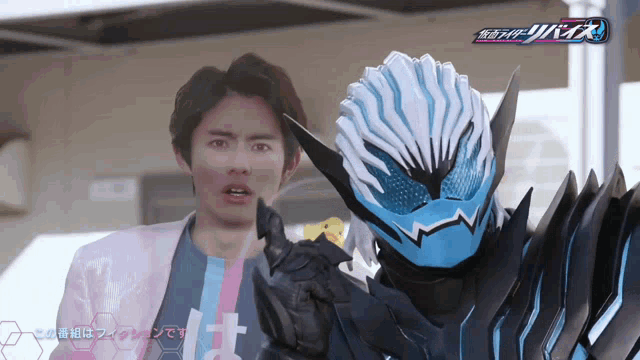 a man in a suit stands next to a masked rider with the word kamen rider on the bottom