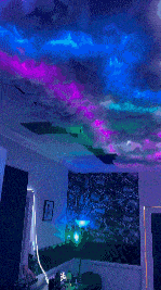 a room with a painting on the ceiling that looks like a galaxy .