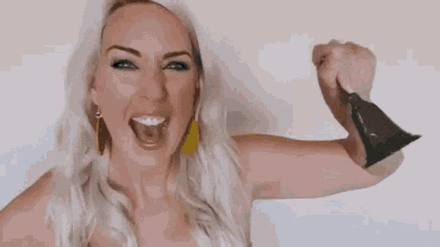 a woman is holding a bell in her hand and shouting ring the bell .