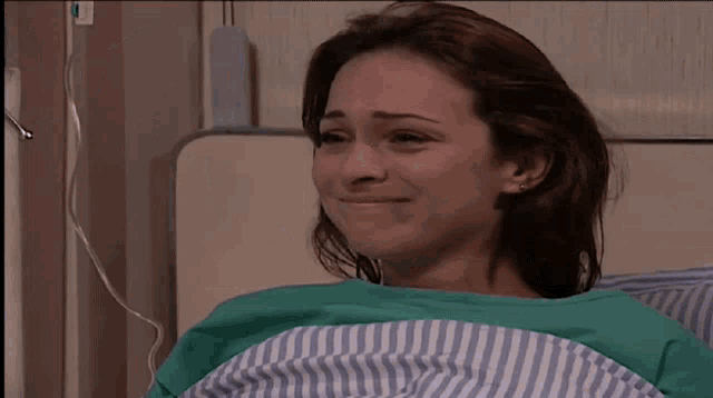 a woman in a hospital bed is talking to a nurse