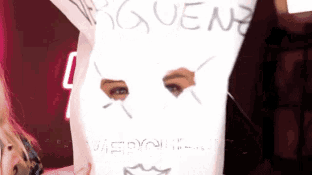 a woman is wearing a white mask with the word gueen written on it ..