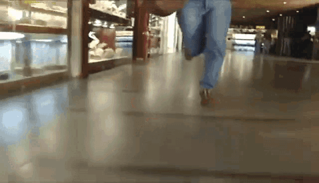 a person is running on a concrete floor in a mall