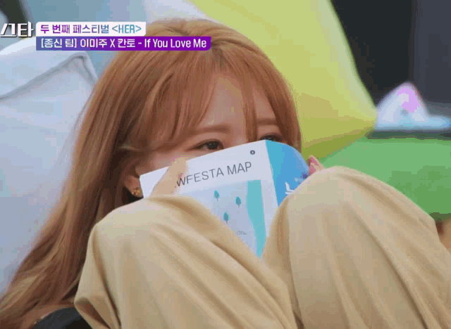 a girl is covering her face with a wfesta map