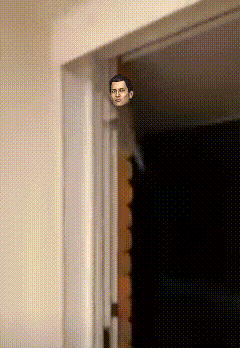 a man 's head is sticking out of a doorway in a room
