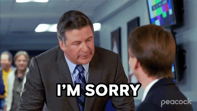 a man in a suit and tie is saying i 'm sorry to another man
