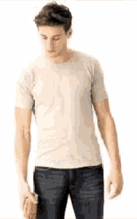a man wearing a white t-shirt and blue jeans is holding a bottle of soda .