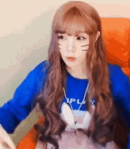 a girl with long brown hair is wearing a blue sweater with a bunny on it .