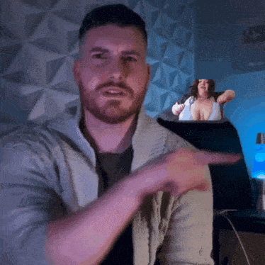 a man with a beard is pointing to a woman in a bikini