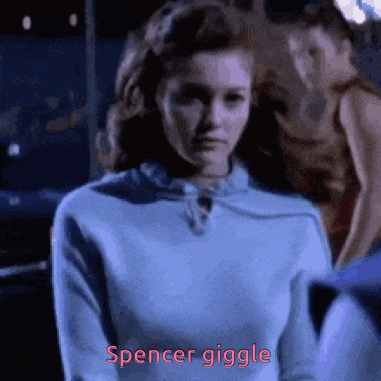 a woman in a blue sweater says spencer giggle in red letters .