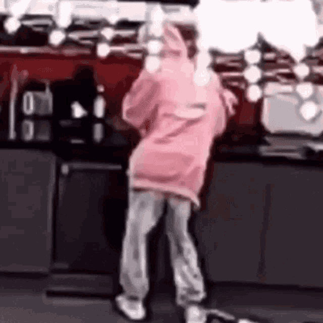 a person in a pink hoodie is standing on a counter .