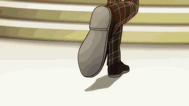 a person wearing plaid pants and black shoes is walking on a white floor .
