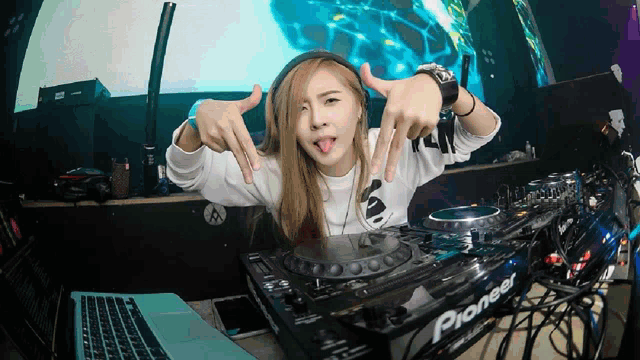 a woman is making a funny face behind a pioneer mixer