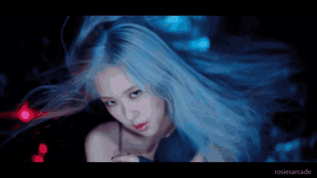 a close up of a woman 's face with blue hair