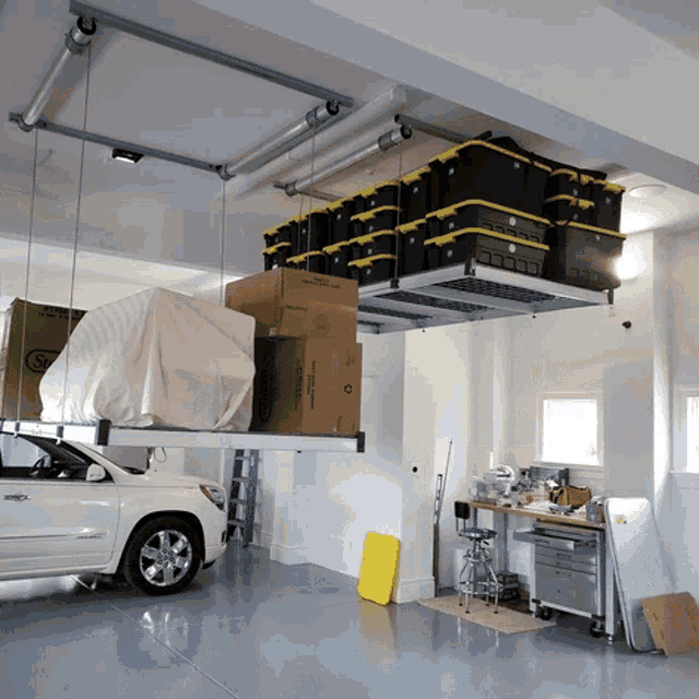 a white car is parked in a garage with boxes hanging from the ceiling including one that says ' s ' on it