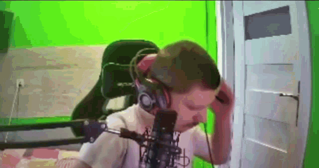 a man wearing headphones is sitting in front of a green screen .