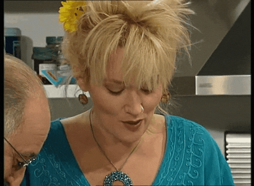 a woman with a flower in her hair wearing a blue shirt